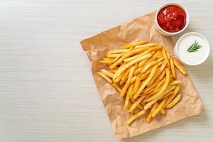 papas fritas con crema agria y salsa de tomate foto