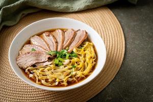 egg noodles with stewed duck in brown soup photo