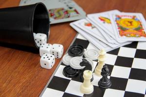 mix of goblet table games dice spanish poker cards chess and checkers photo