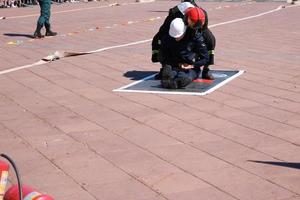 Men firefighter in fireproof suit and helmet saves drags pulls worker man out of danger photo