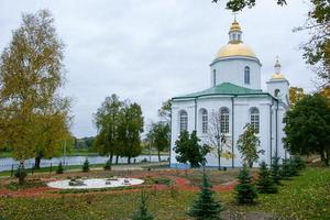 A large white stone church with a golden dome and a bell in eastern Europe is a Christian orthodox for the prayers of God photo