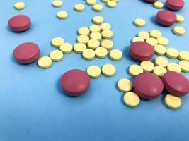 medicamentos farmacéuticos médicos redondos multicolores rojos y amarillos para el tratamiento de enfermedades que matan microbios y virus píldoras y medicamentos vitamínicos para el coronavirus en un fondo azul