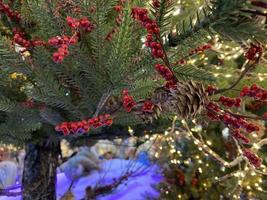 Fir tree branches with glowing yellow Christmas light as background photo