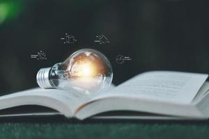 bombilla de luz brillante e icono con libro. idea de éxito empresarial y concepto de educación o aprendizaje en línea. logro e inspiración de la persona de negocios. tecnología, crea imaginación para inspirarte. foto