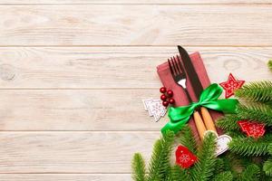 Top view of festive cutlery on new year wooden background. Christmas decorations with empty space for your design. Holiday dinner concept photo