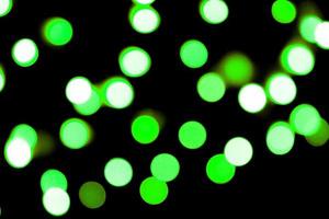 Unfocused abstract colourful bokeh black background. defocused and blurred many round green light photo