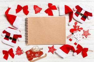 Top view of notebook on wooden background made of Christmas decorations. New Year concept photo