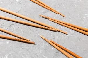 Many bamboo chopsticks on black cement stone background, top view with copy space. a lot of sushi sticks in the form of an ornament photo