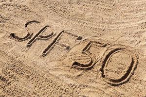 Sun protect factor fifty concept. SPF 50 word written on the beach photo