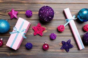 Top view Christmas ball, gift and creative decorations on wooden background. New Year holiday concept with copy space photo