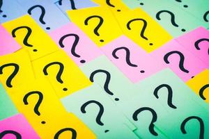 Question marks background. Colorful paper notes with question marks. Concept image. Closeup top view toned photo