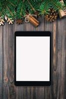 Digital tablet mock up with rustic Christmas vintage, toned wood background decorations for app presentation. top view with copy space photo