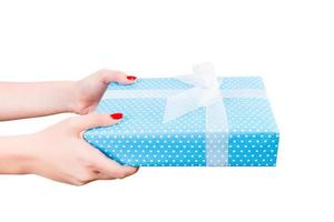 Woman hands give wrapped Christmas or other holiday handmade present in blue paper with white ribbon. Isolated on white background, top view. thanksgiving Gift box concept photo