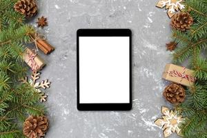 Digital tablet mock up with rustic Christmas gray cement background decorations for app presentation. top view with copy space photo