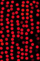 Unfocused abstract red bokeh on black background. defocused and blurred many round light photo