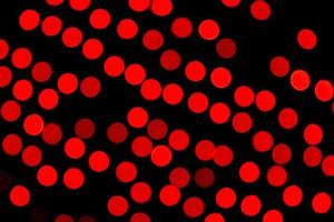 Unfocused abstract red bokeh on black background. defocused and blurred many round light photo