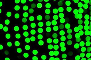 Unfocused abstract green bokeh on black background. defocused and blurred many round light photo