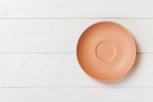 Orange round plate top view on a background of old wood table plank. matte round plate photo