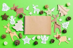 Christmas green background with holiday toys and decorations. Top view of notebook. Happy New Year concept photo