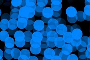 Unfocused abstract dark blue bokeh on black background. defocused and blurred many round light photo