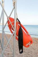 Beach life-saving. lifeguard tower with orange buoy on the beach. rescue buoy on the iron rescue post photo