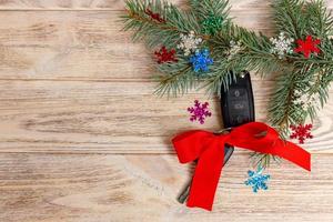Close-up view of car keys with red bow as present on wooden background photo