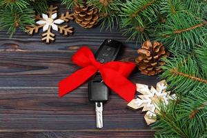 Close-up view of car keys with red bow as present on wooden background photo