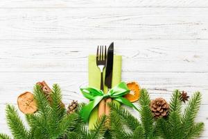 Top view of utensils on festive napkin on wooden background. Christmas decorations with dried fruits and cinnamon. New year dinner concept with copy space photo