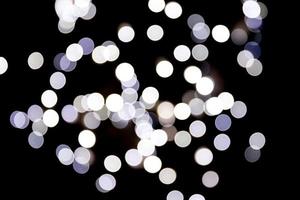 Abstract bokeh of white city lights on black background. defocused and blurred many round light photo