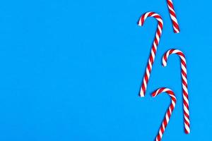 Christmas candy can in row on blue background. Flat lay. Copy space photo