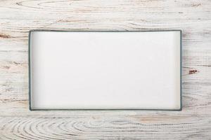 White rectangular empty open box, top view on white wooden background. top view photo