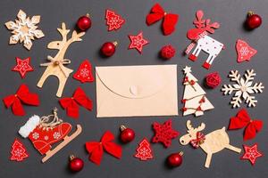 Christmas black background with holiday toys and decorations. Top view of craft envelope. Happy New Year concept photo