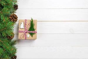 Christmas gift box wrapped in recycled paper, with ribbon bow, with ribbon on rustic background. Holiday concept photo