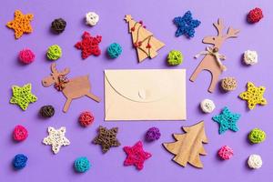 Top view of craft envelope. New Year decorations on purple background. Festive stars and balls. Merry Christmas concept photo