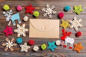 Top view of envelope on festive wooden background. Christmas toys and decorations. New Year time concept photo