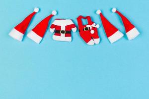 Top view of colorful holiday background made of Santa hats and clothes. Merry Christmas concept with copy space photo