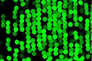 Unfocused abstract green bokeh on black background. defocused and blurred many round light photo