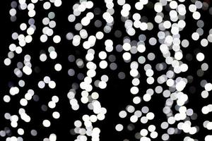 Abstract bokeh of white lights on black background. defocused and blurred many round light photo