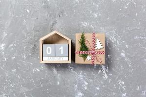 calendario con fecha 1 de enero y cajas de regalo sobre fondo de color. concepto de navidad foto