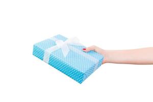 Woman hands give wrapped Christmas or other holiday handmade present in blue paper with white ribbon. Isolated on white background, top view. thanksgiving Gift box concept photo