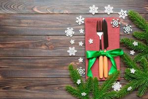 Top view of festive cutlery on new year wooden background. Christmas decorations with empty space for your design. Holiday dinner concept photo
