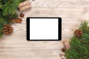 Digital tablet mock up with rustic Christmas wood background decorations for app presentation. top view with copy space photo