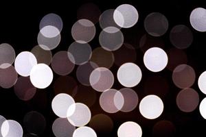 Unfocused abstract white bokeh on black background. defocused and blurred many round light photo