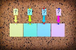 A sticker with a question mark is attached to the cork board. Empty stickers for copy space. photo