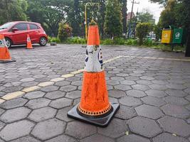 red safety cone in the parking lot outside the mall photo