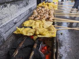 albóndigas a la parrilla. comida local tradicional de la calle en indonesia donde el proceso de fabricación se asa a la parrilla con carbón caliente foto