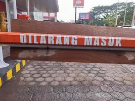 un letrero que dice dilarang masuk dice que no hay entrada en indonesio en el estacionamiento del centro comercial foto