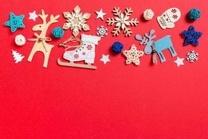 Top view of holiday toys and decorations on red Christmas background. New Year time concept with copy space photo