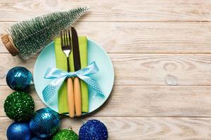 Holiday composition of Christmas dinner on wooden background. Top view of plate, utensil and festive decorations. New Year Advent concept with copy space photo