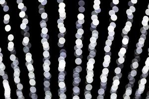 Abstract bokeh of white lights on black background. defocused and blurred many round light photo